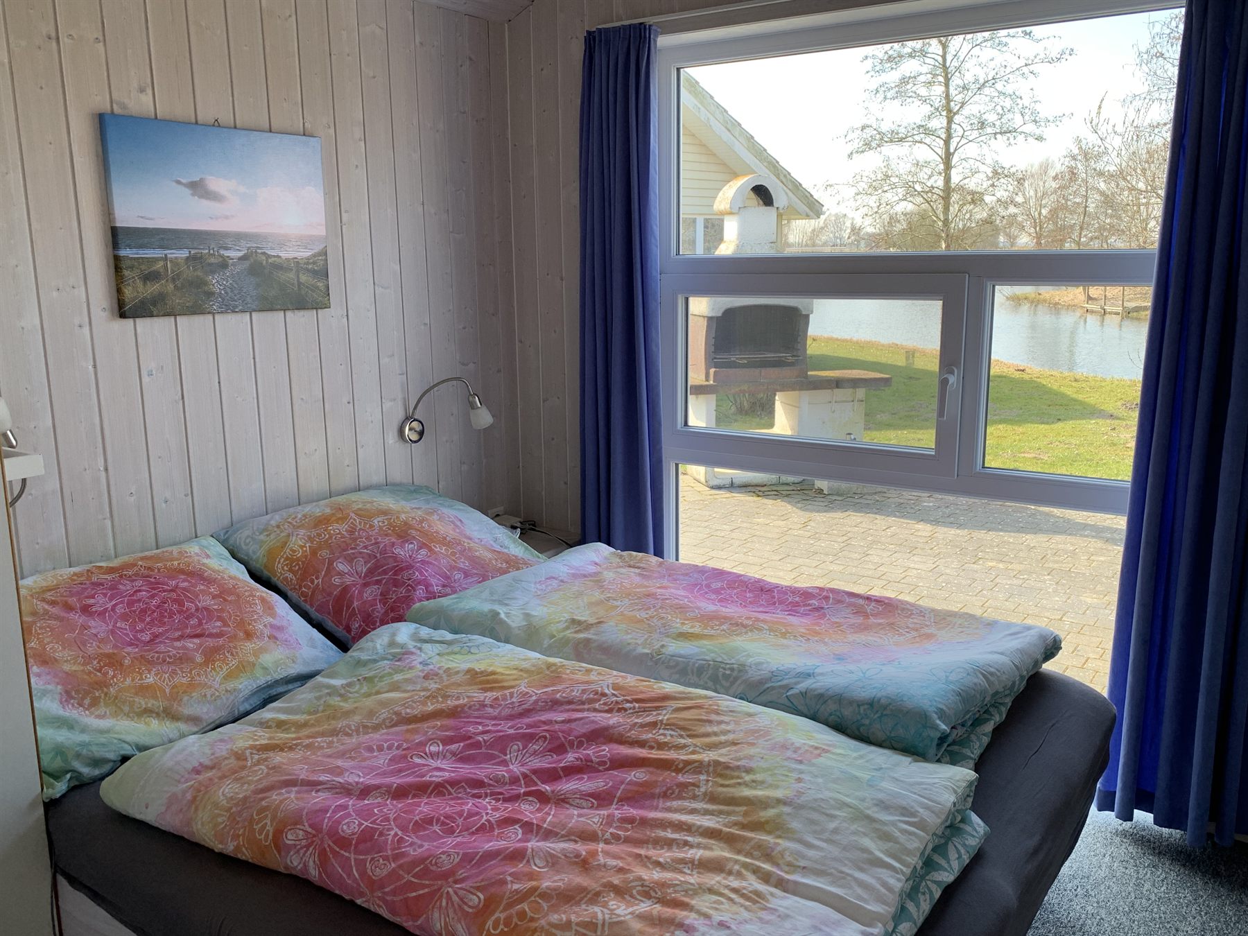 Schlafzimmer im tierfreien Ferienhaus AVALON in Otterndorf mit Blick zum Wasser